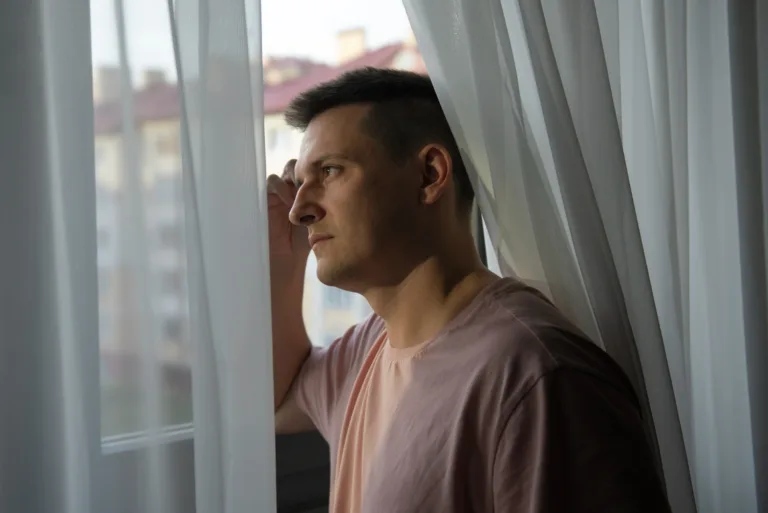 Person sitting quietly looking out of a window, reflecting on how to manage overwhelming emotionsPerson sitting quietly looking out of a window, reflecting on how to manage overwhelming emotions